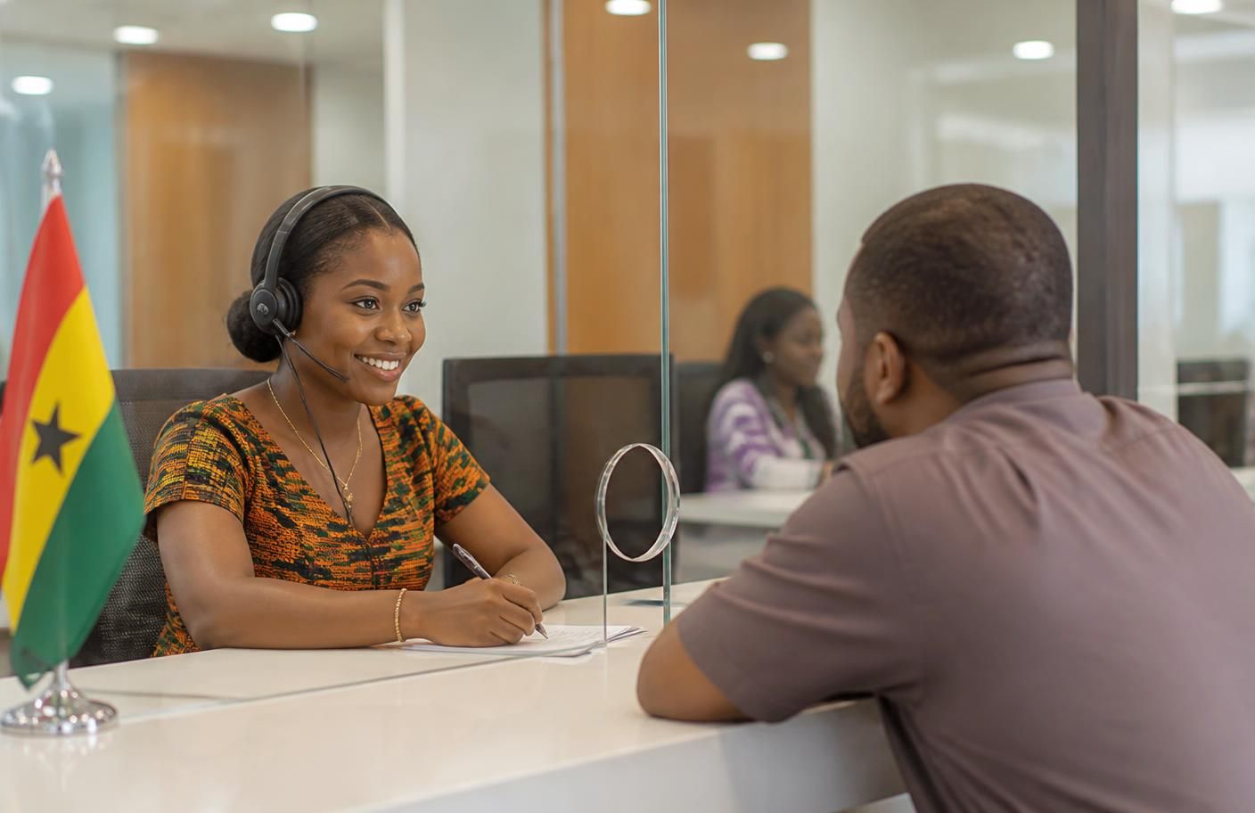 A NITA support officer assisting a visitor at the service desk